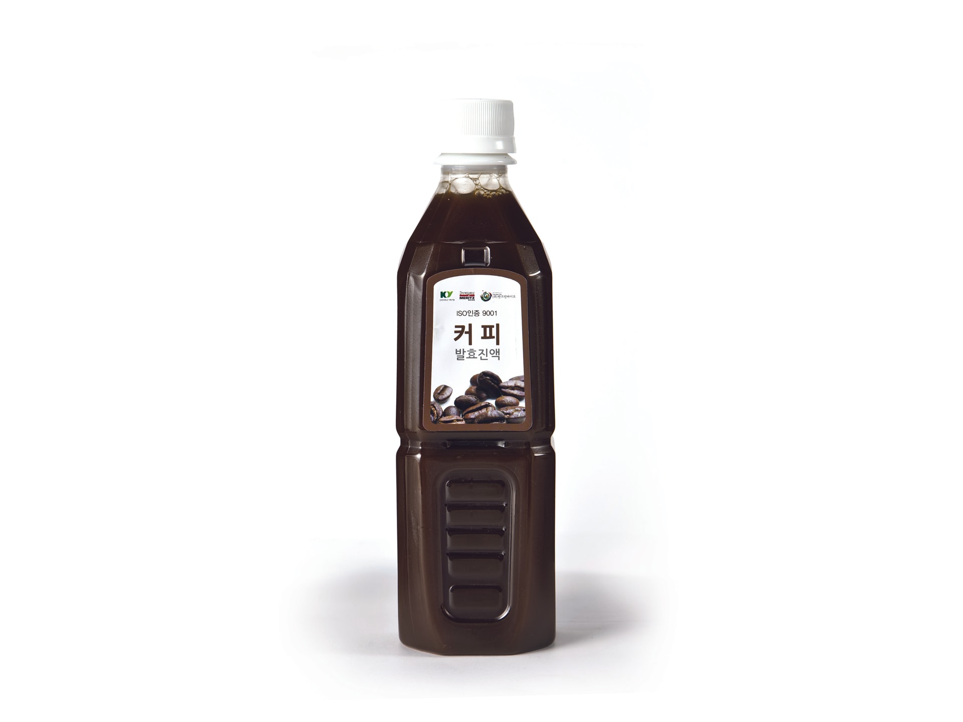 발효커피 진액 500ml 병과 커피잔이 함께 놓인 이미지